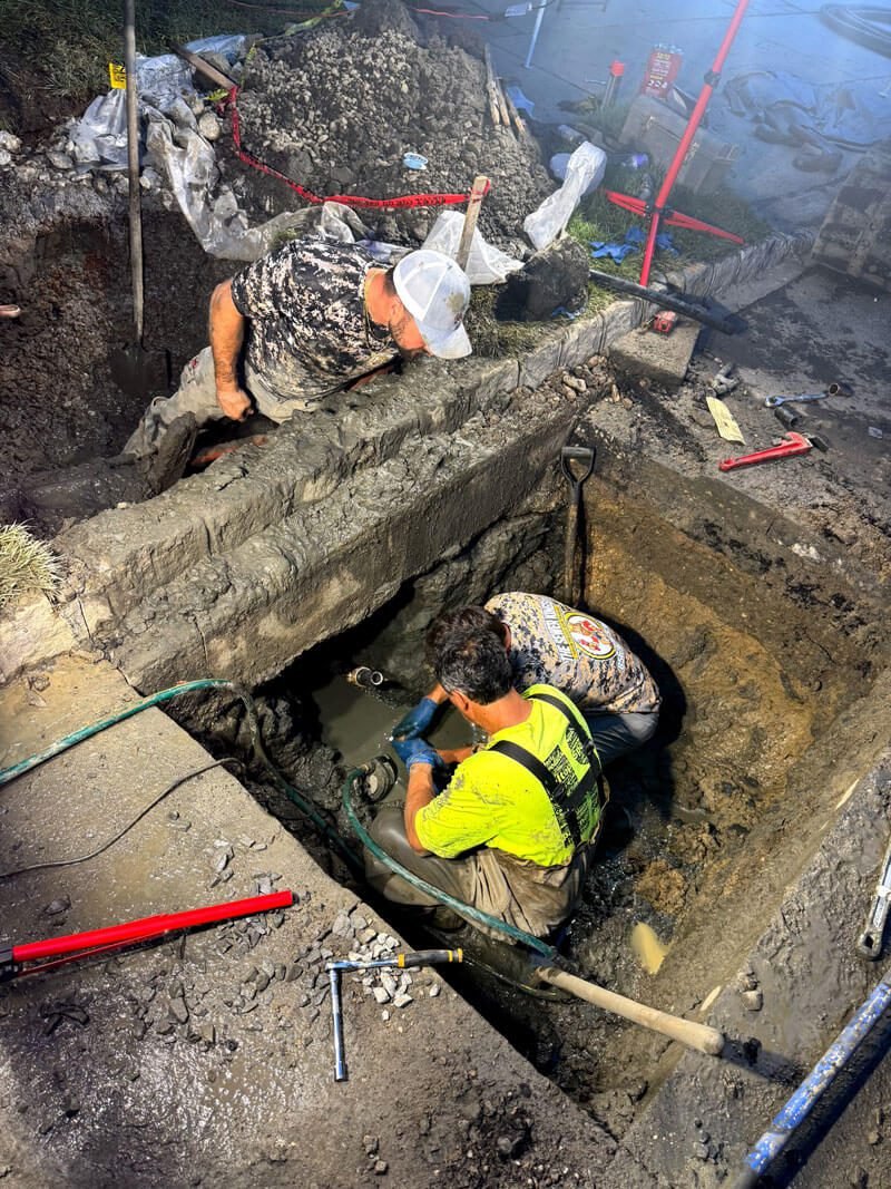 Drain & Sewer Services Workers repairing sewer pipe in trench