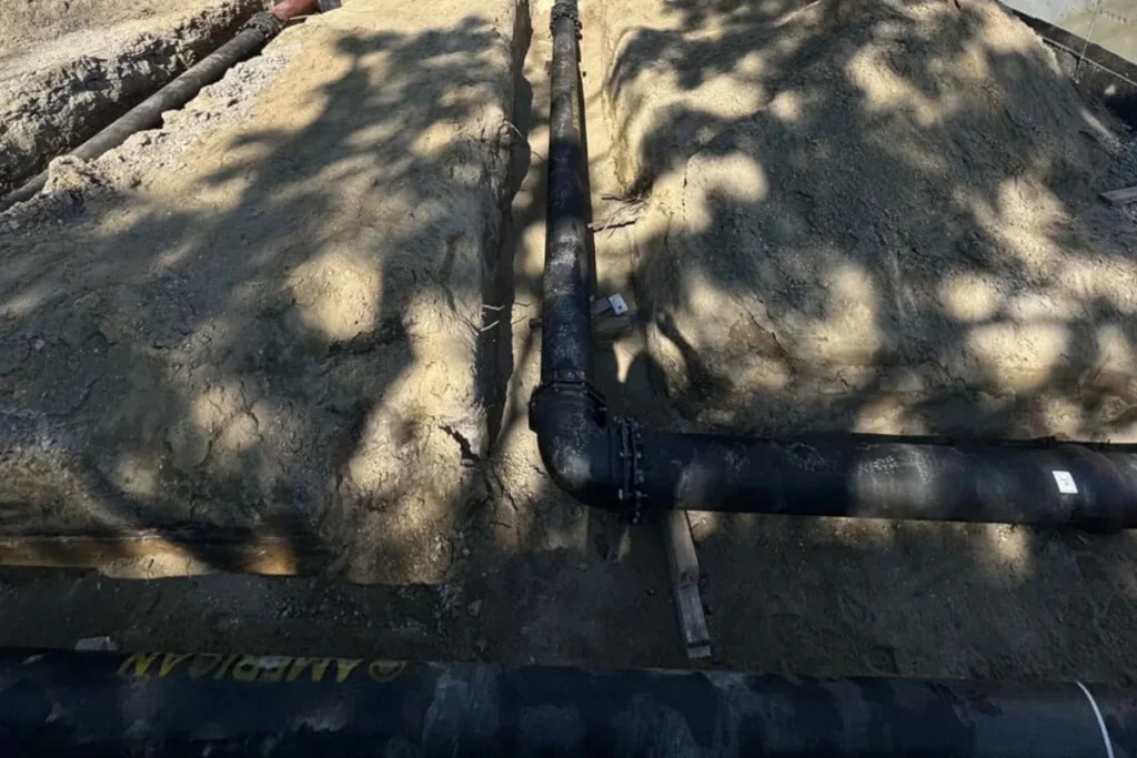 A long sewer pipe run installed across a commercial trench in Evesham NJ, illustrating infrastructure work involved in commercial sewer cleaning projects.