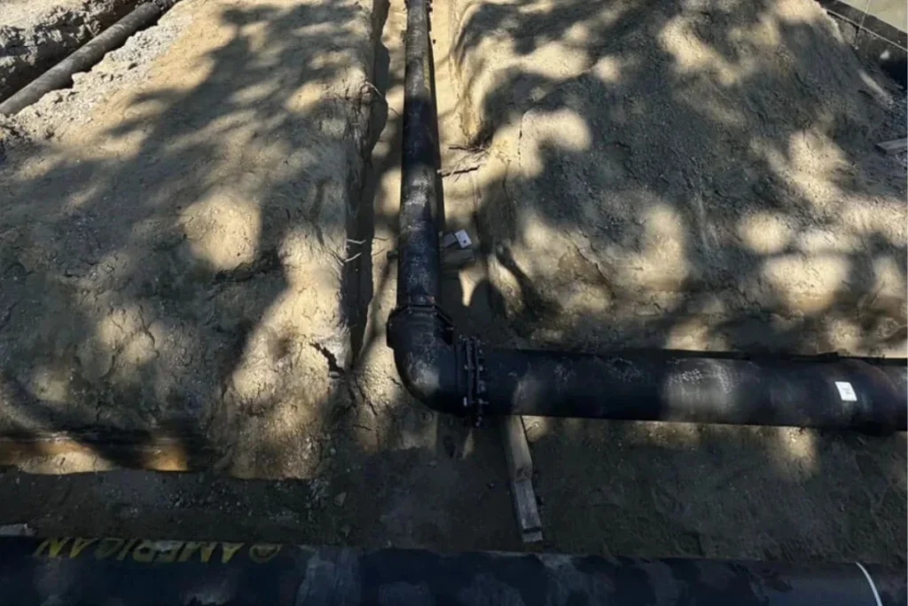 Sewer line repair in South New Jersey with exposed underground piping laid in a trench, illustrating professional sewer pipe replacement work.