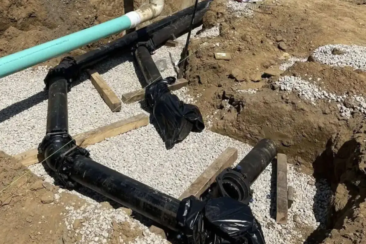 Sewer repair work in Evesham Township, NJ featuring newly installed underground piping set on a gravel base during a commercial excavation project
