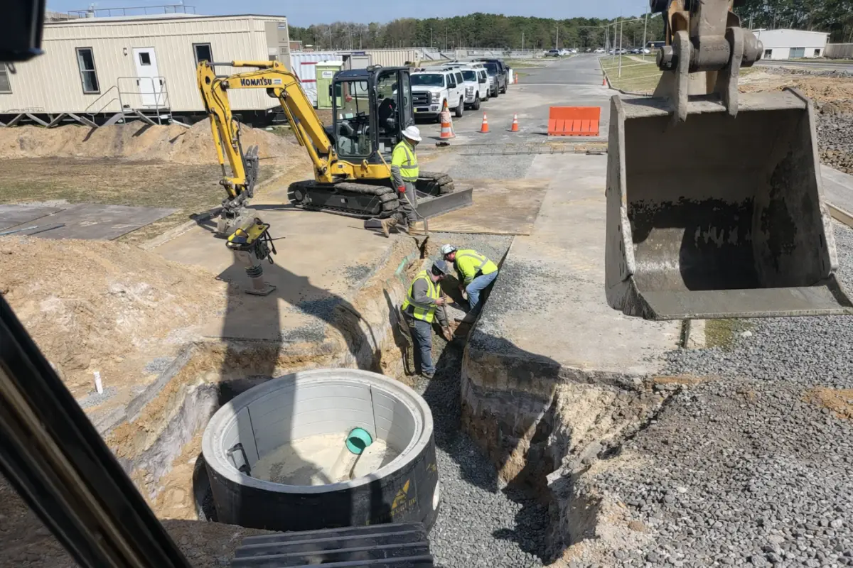 Septic treatment system installation in Evesham, NJ showing treatment tank placement with excavation equipment and gravel base preparation.