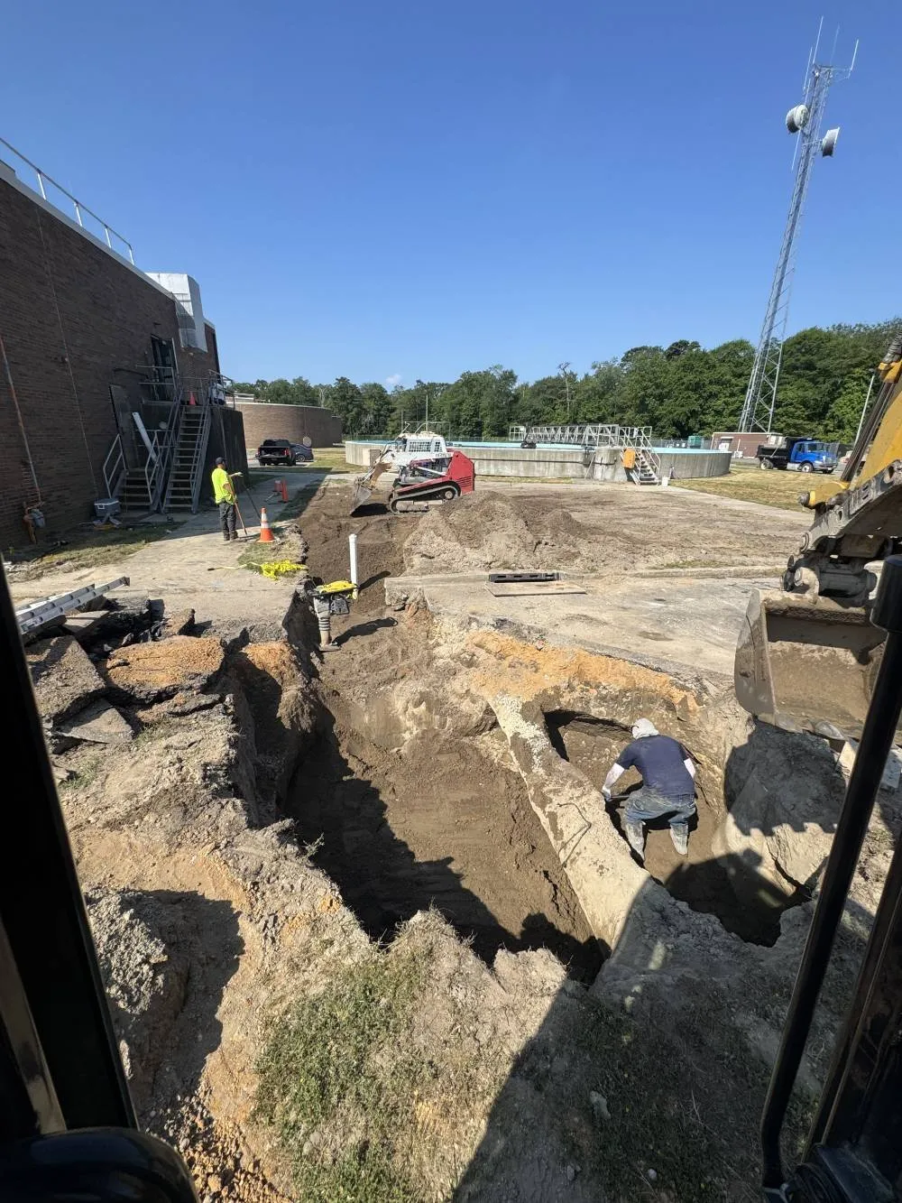 Excavator digging for drain field replacement and sewer line installation in South Jersey