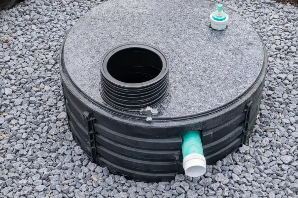 Inspector checking septic access opening and baffles during a New Jersey real estate inspection