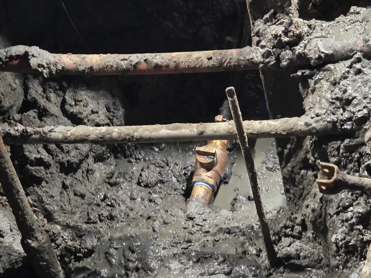 Pipe Bursting vs. Pipe Lining: Which Trenchless Method Is Right for You? Old corroded metal pipes exposed in a muddy excavation