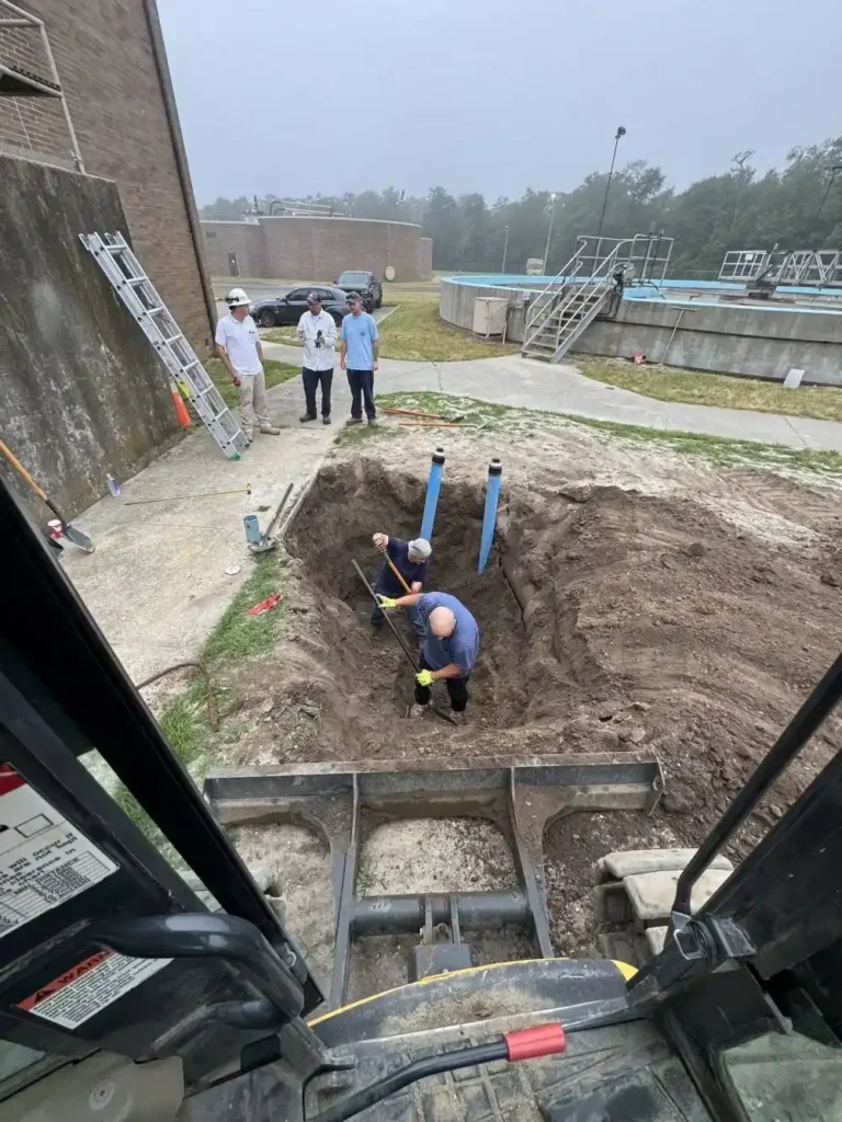 Crew working in a small access pit with new pipe, trenchless sewer line replacement in Cherry Hill Township, NJ