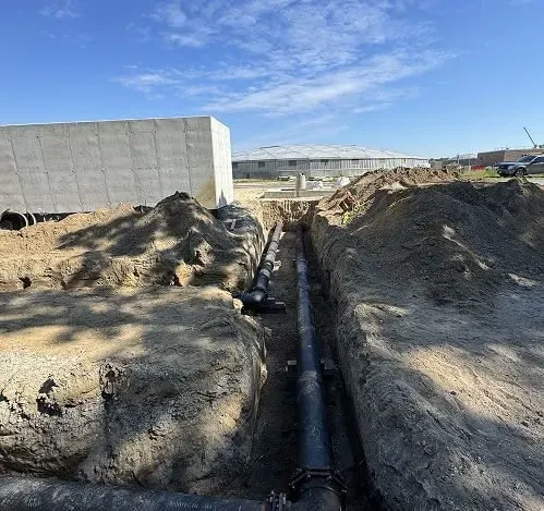 Long run of black sewer pipe laid in a trench for trenchless sewer line replacement in Cherry Hill Township, NJ