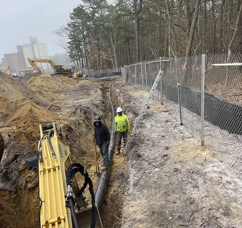 New pipe line in a long trench beside a fence, sewer line replacement work near Cherry Hill Township, NJ