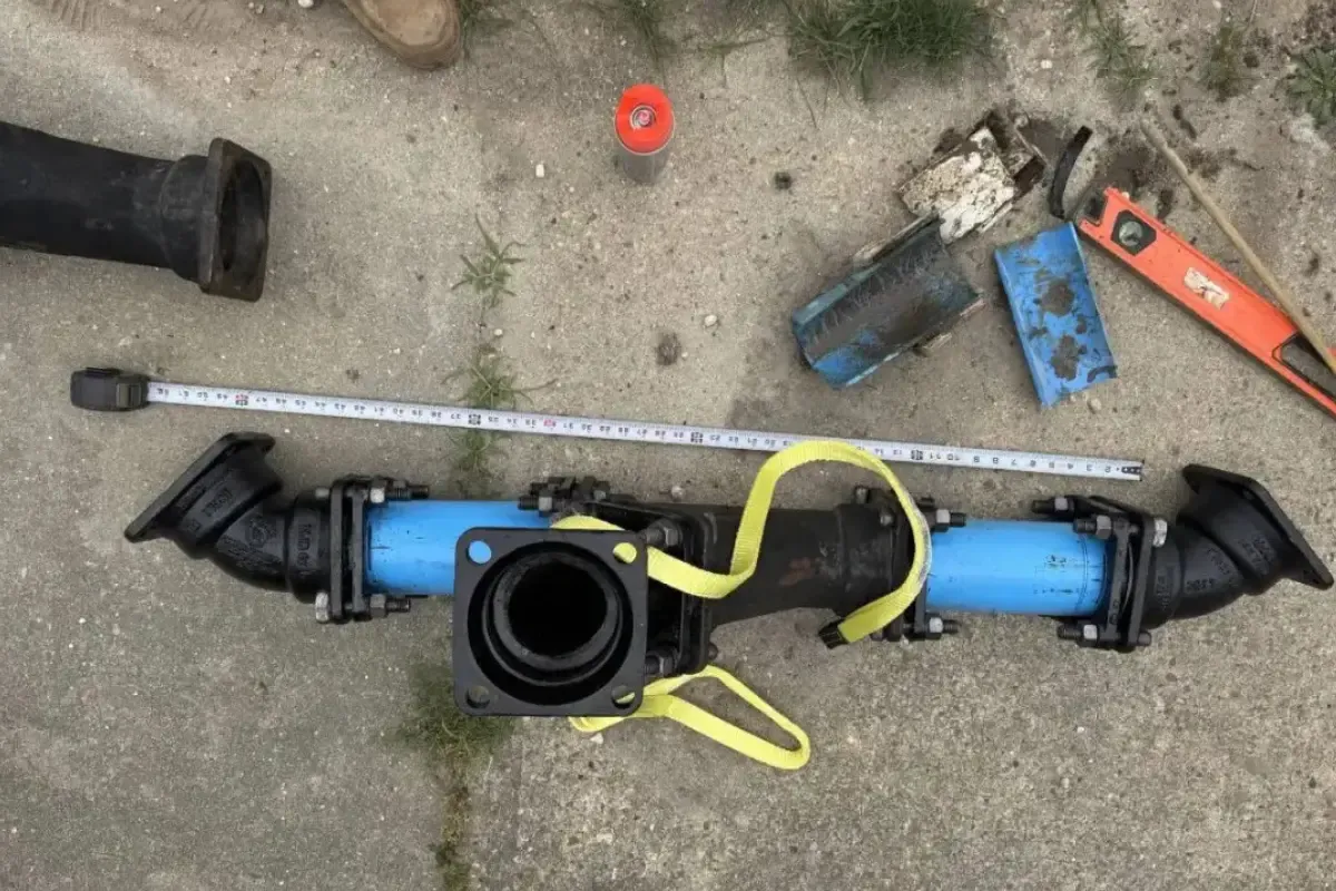 How Much Does Trenchless Sewer Line Replacement Cost? New black pipe fittings and couplings laid out on pavement next to a tape measure
