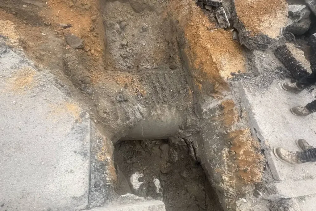 Protecting Your Sewer Line During a Driveway or Patio Project in Evesham Sewer trench cut through asphalt and tunneled under a concrete slab in Evesham, NJ