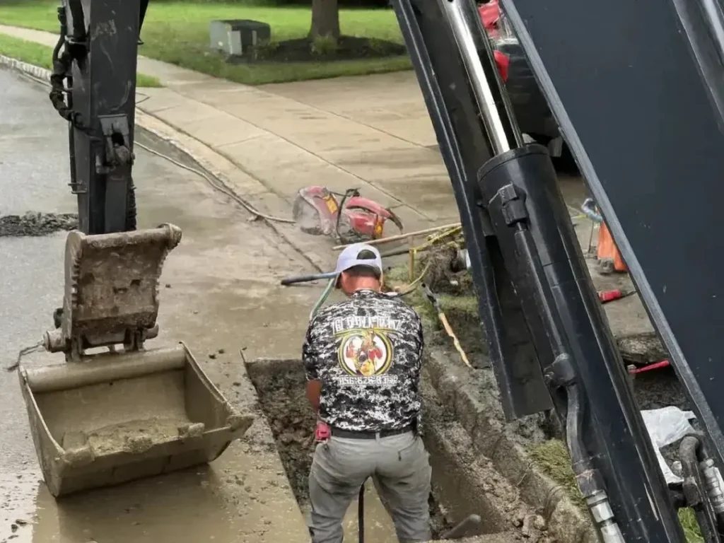What to Ask a Sewer Line Repair Contractor in Evesham Before You Hire Sewer Kings crew member and excavator at an open sewer line trench on an Evesham, NJ street