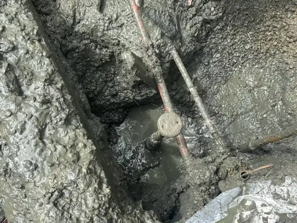 How Heavy Rain and Groundwater Get Into Cracked Sewer Lines in Evesham Groundwater filling the dig around an opened sewer line during a repair in Evesham, NJ