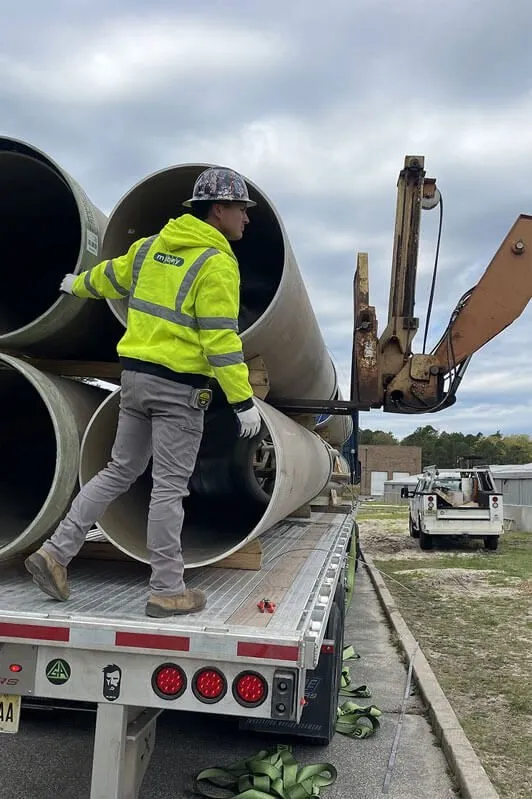 Sewer Kings crew member unloading sewer pipe for a South Jersey job